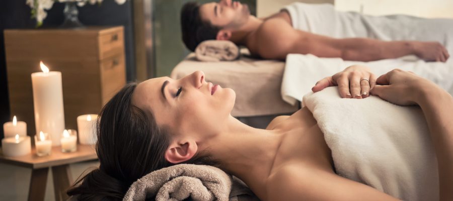 Young man and woman lying down on massage beds at Asian luxury spa and wellness center
